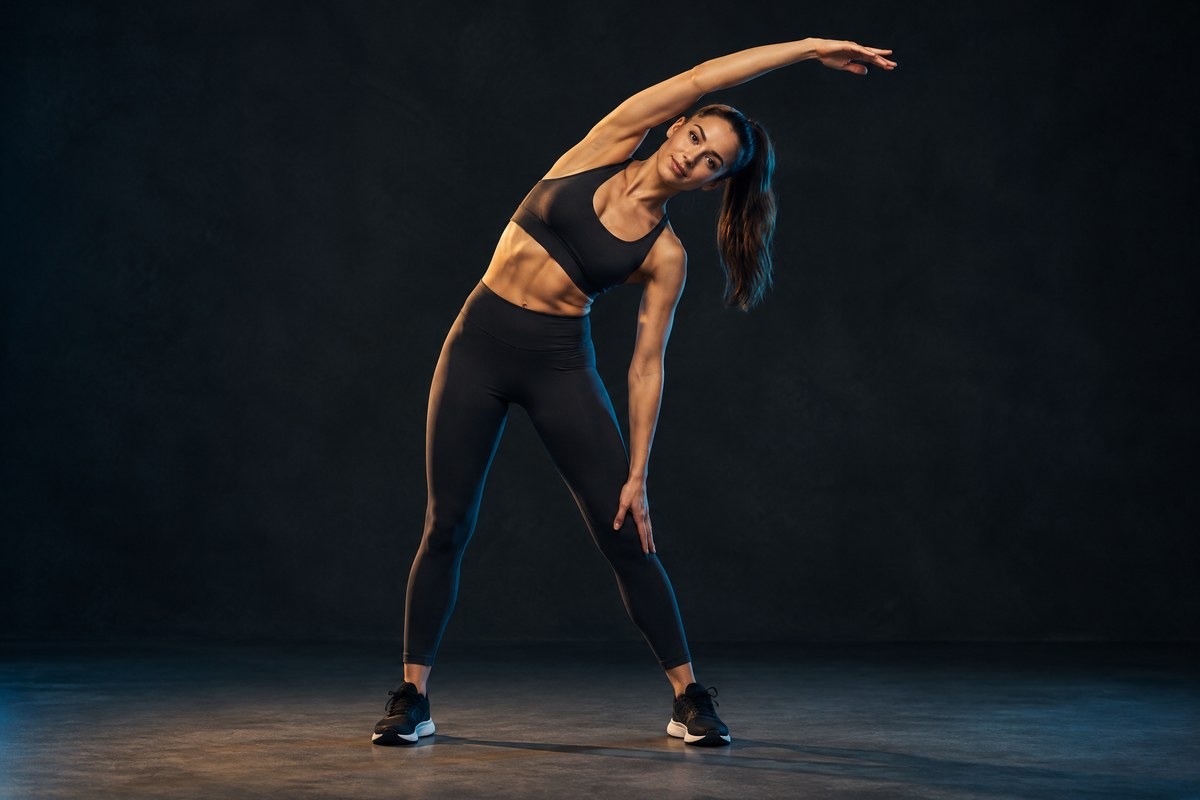 Woman performing a standing side bend while developing flexibility
