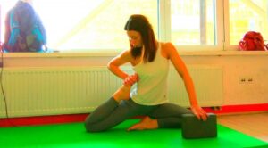Yoga block assisted stretching exercise for improved flexibility in bright studio