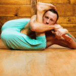 Person stretching on a mat, practicing flexibility and relaxation exercises.